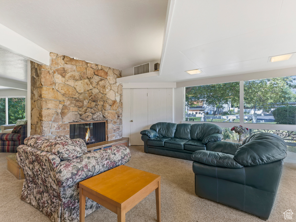 Carpeted living room featuring plenty of natural light and a fireplace