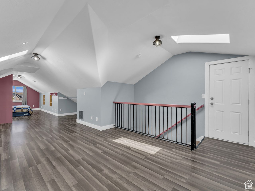 Additional living space with a skylight, lofted ceiling, and wood finished floors