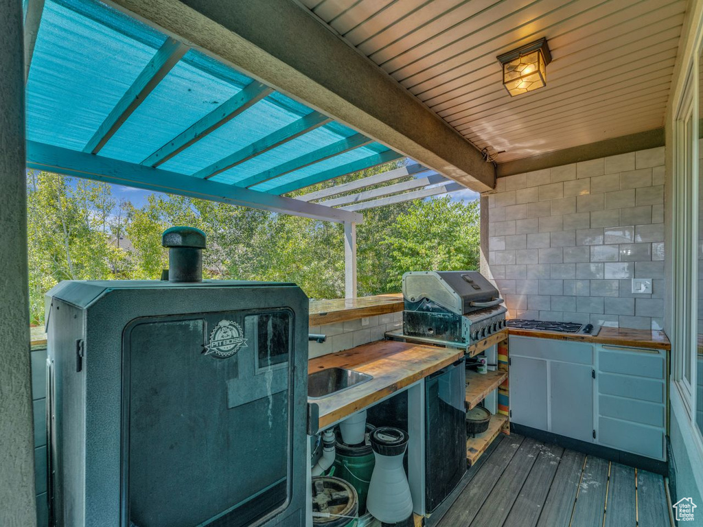 Wooden deck featuring area for grilling