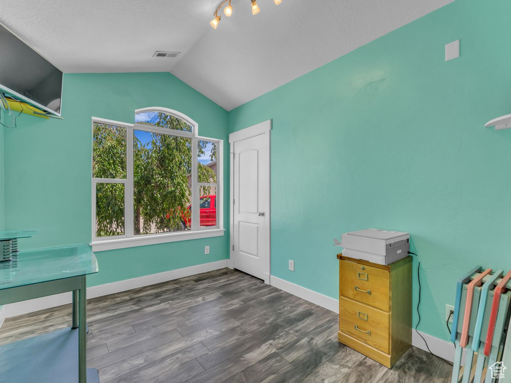Unfurnished office featuring vaulted ceiling and wood finished floors