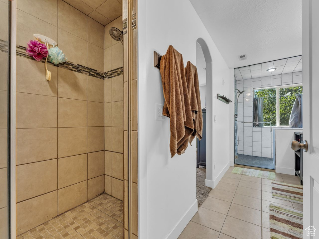 Bathroom with a shower stall, tile patterned floors, and recessed lighting