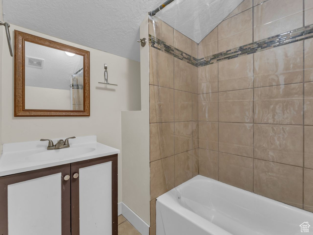 Full bath with vanity, shower / bath combination with curtain, and a textured ceiling