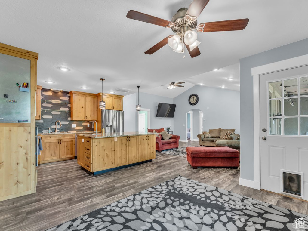 Living area featuring dark wood-style floors, ceiling fan, lofted ceiling, recessed lighting, and arched walkways