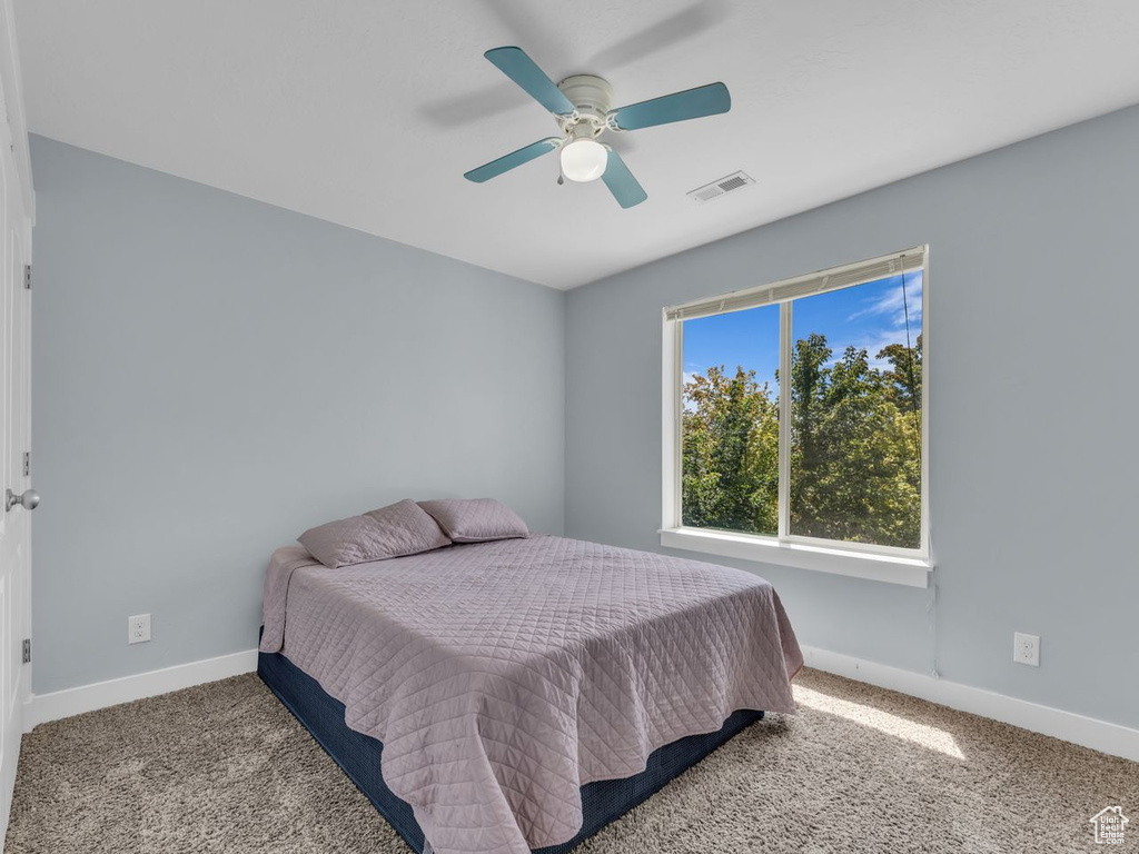 Carpeted bedroom with baseboards and ceiling fan