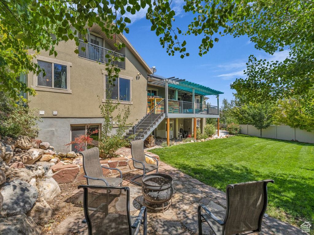 Back of property featuring stairway, an outdoor fire pit, stucco siding, a pergola, and a deck