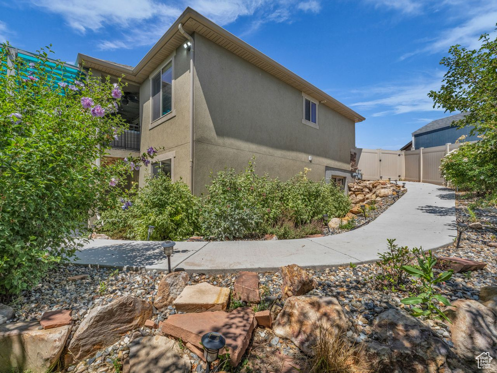View of side of home with stucco siding and a gate