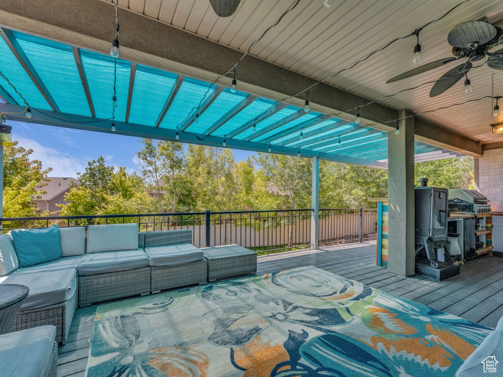 Deck with outdoor lounge area, a ceiling fan, and a grill