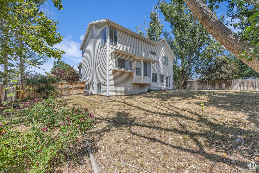 Rear view of house featuring a fenced backyard