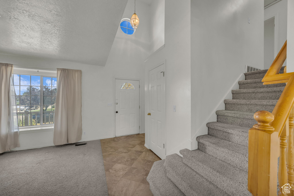 Entryway featuring stairs and high vaulted ceiling