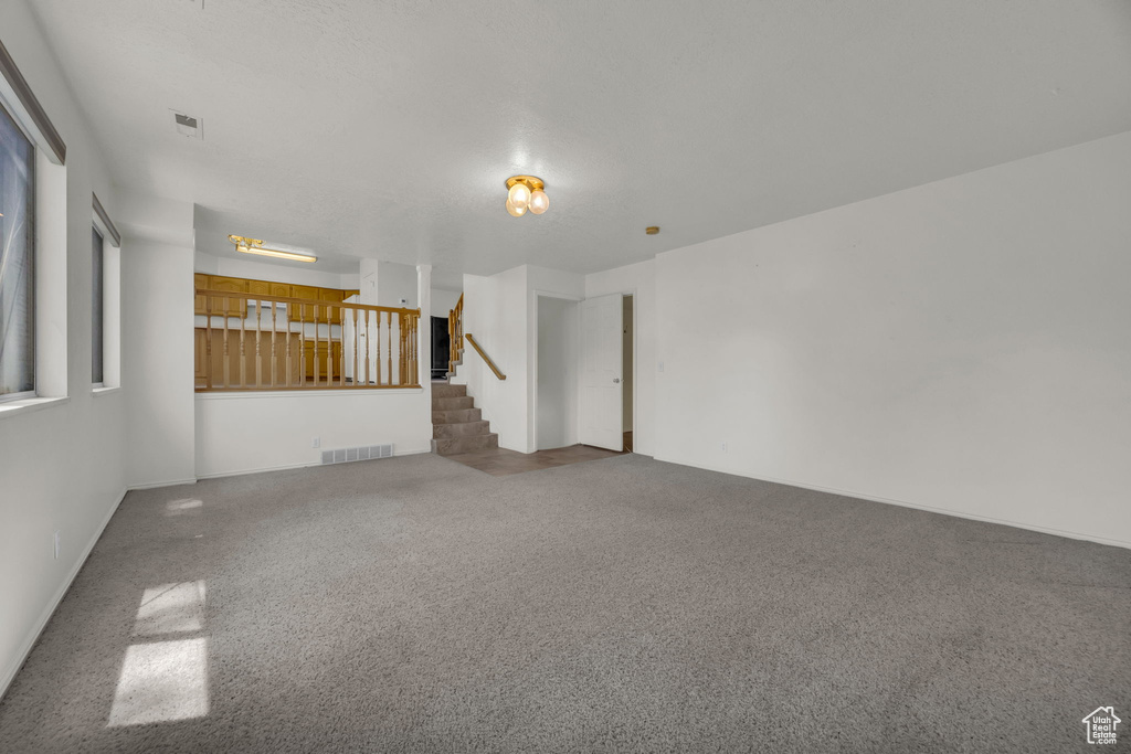 Carpeted spare room with stairs
