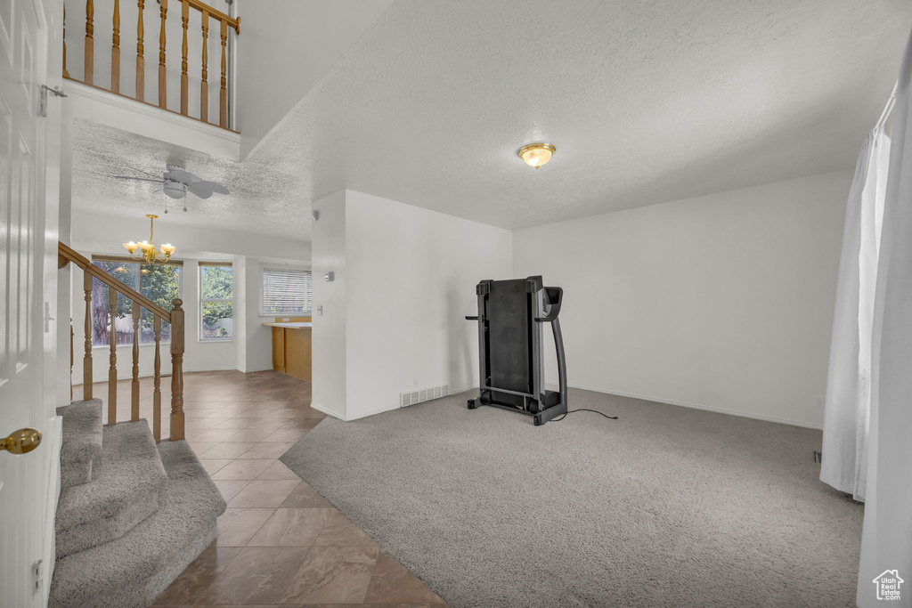 Workout room with a textured ceiling and a chandelier