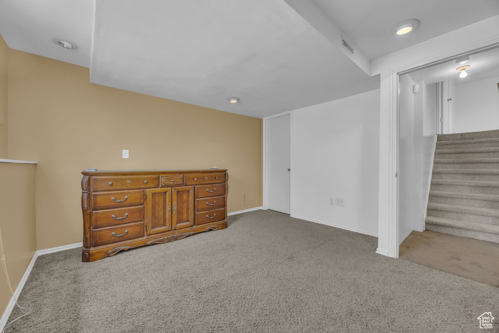 Basement with carpet floors, stairs, and recessed lighting