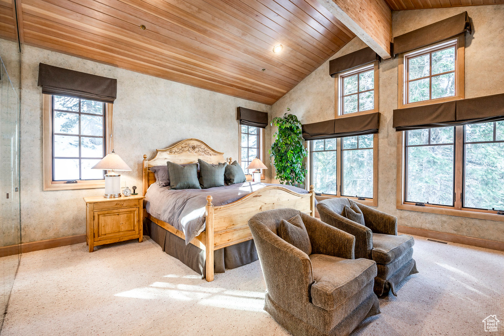 Bedroom with a wooden ceiling with exposed beams and high vaulted ceiling