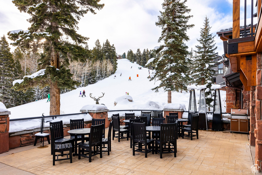 Snow covered patio featuring a patio area and outdoor dining area