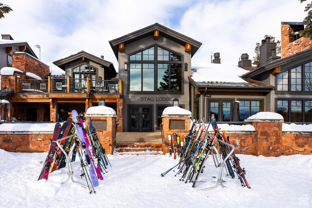 Snow covered property featuring french doors and a chimney