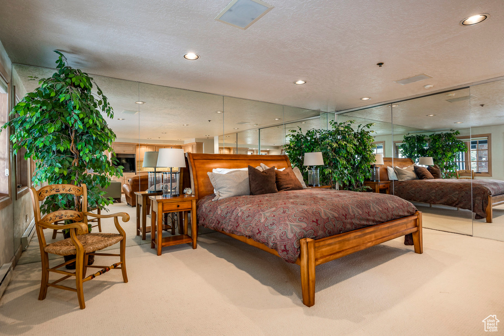 Bedroom featuring carpet floors, recessed lighting, and a textured ceiling