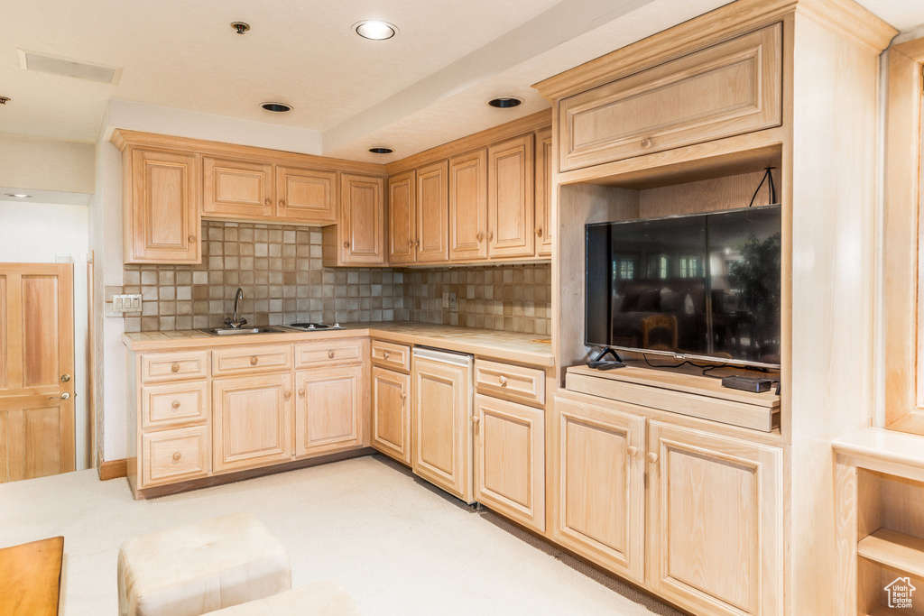Kitchen with light brown cabinets, backsplash, and recessed lighting