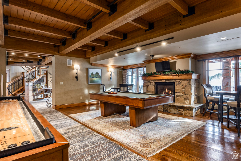 Rec room featuring hardwood / wood-style floors, healthy amount of natural light, a wooden ceiling with exposed beams, a stone fireplace, and billiards
