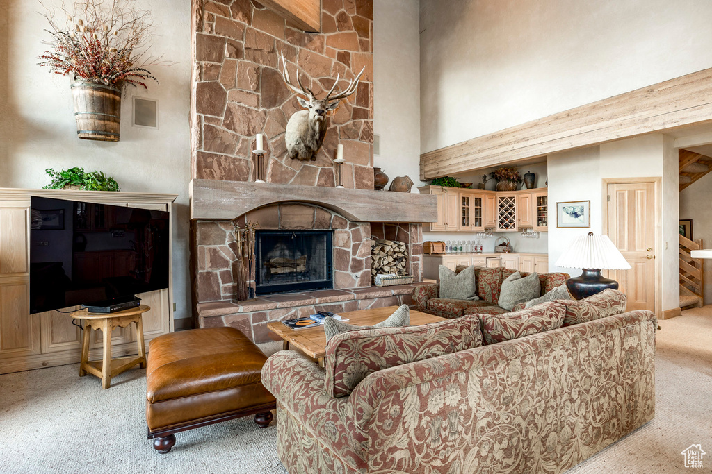 Carpeted living area with a high ceiling and a fireplace