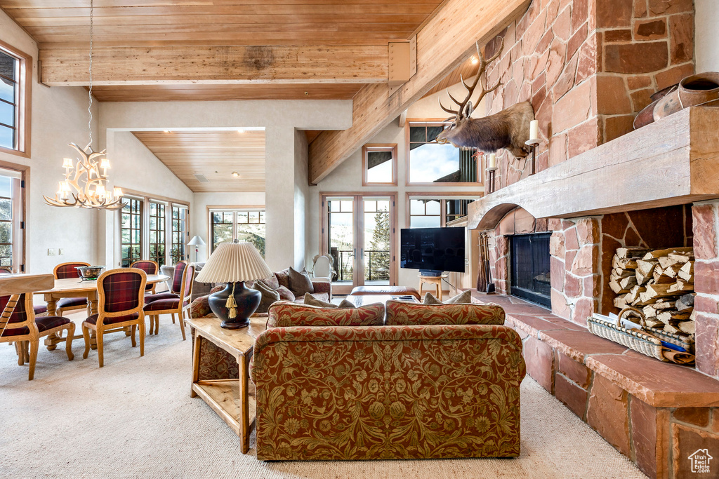 Carpeted living area with wooden ceiling, a fireplace, and a chandelier