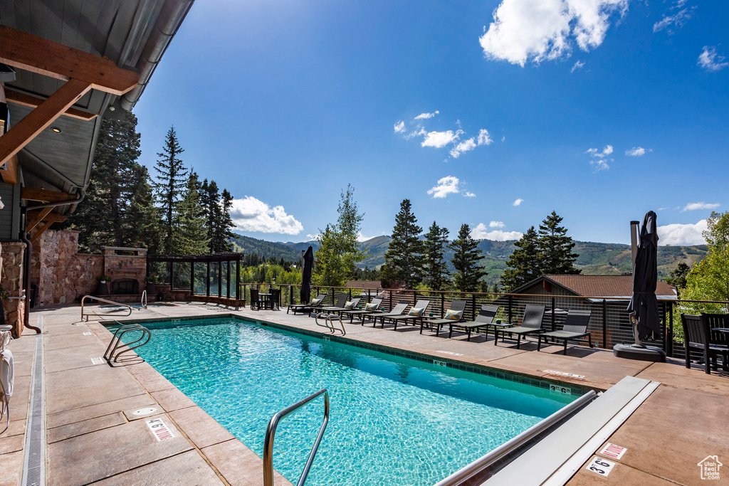 Community pool featuring a mountain view and a patio