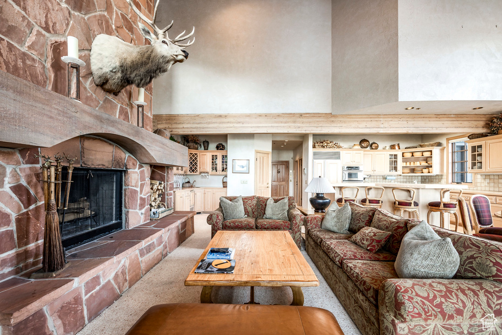 Living room featuring a towering ceiling, carpet, and a fireplace