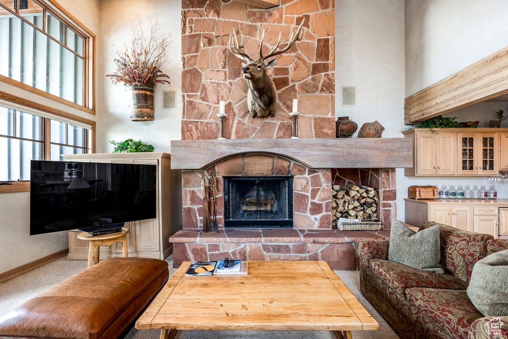 Living room with a towering ceiling and a stone fireplace