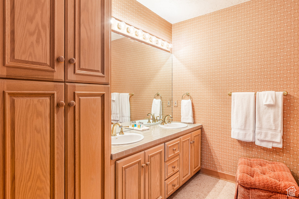 Bathroom with double vanity and wallpapered walls