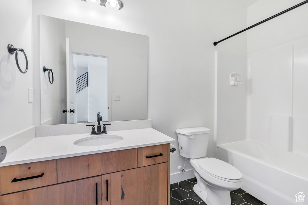 Bathroom with tile patterned floors, vanity, and shower / washtub combination