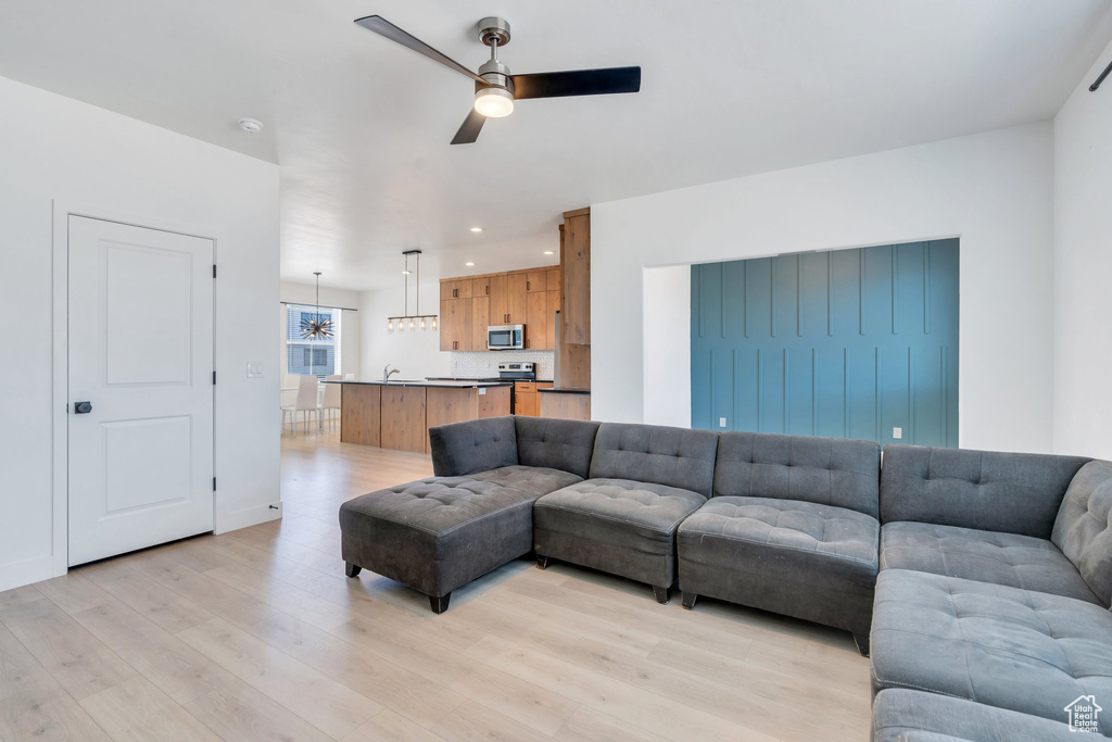 Living area with a ceiling fan, light wood-type flooring, and recessed lighting
