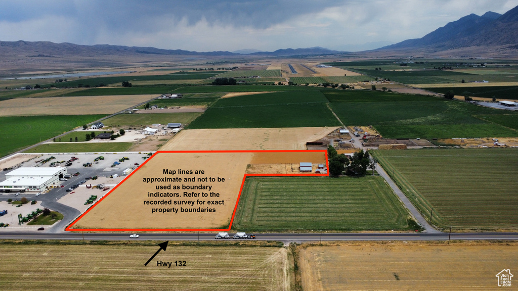 View of rural area with rows of crops, property parcel outlined, and mountains