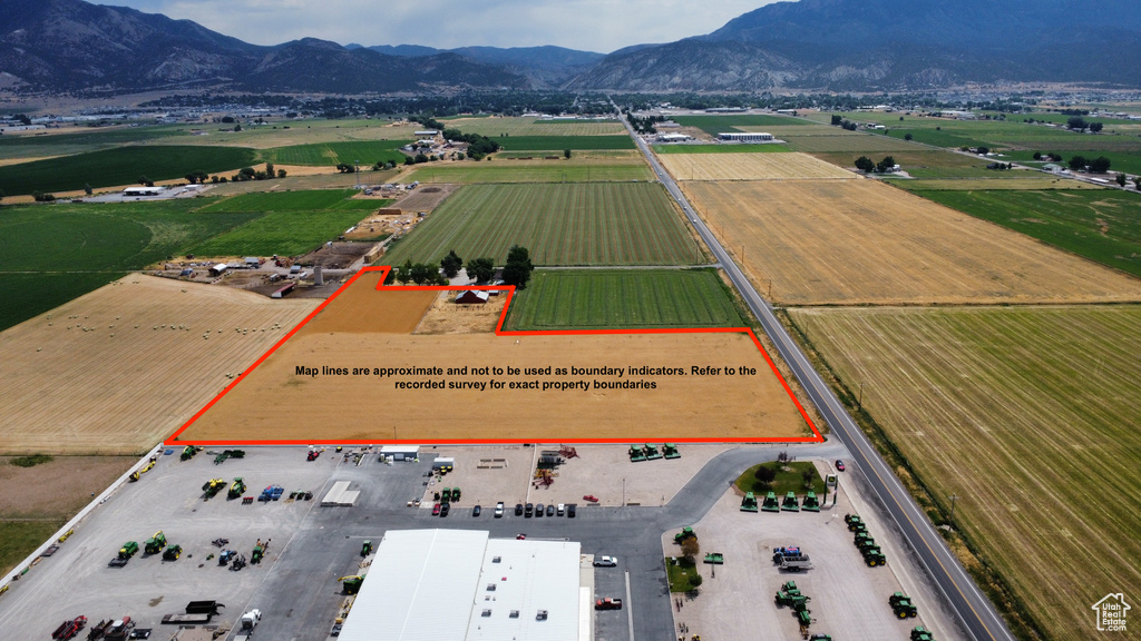 Overview of rural landscape featuring mountains, property parcel outlined, and rows of crops