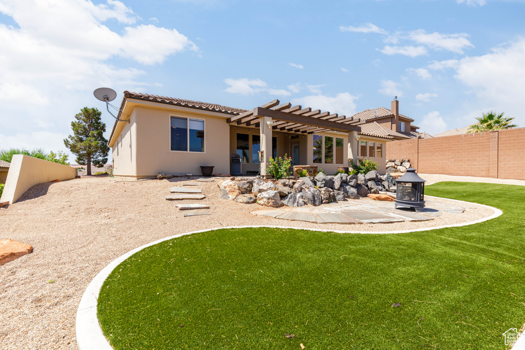 Back of house with a pergola, a tiled roof, a fenced backyard, a patio, and stucco siding