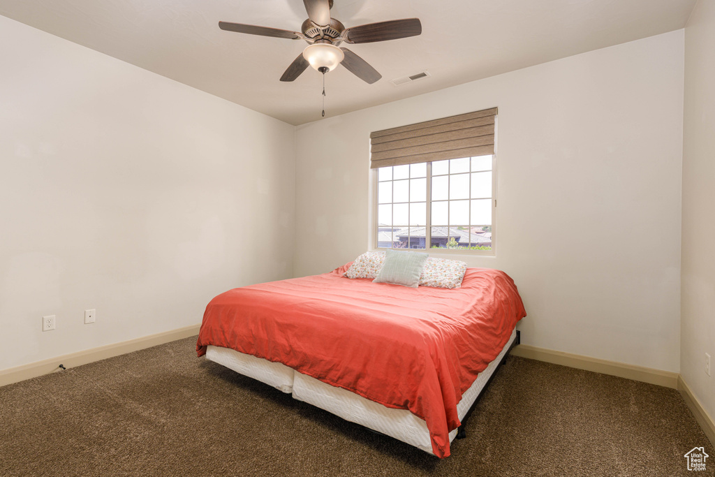 Carpeted bedroom with baseboards and a ceiling fan