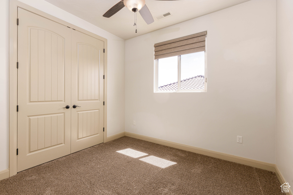 Unfurnished bedroom with carpet flooring, a closet, and ceiling fan