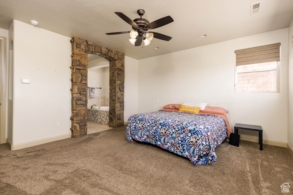 Bedroom featuring carpet floors, ceiling fan, and arched walkways