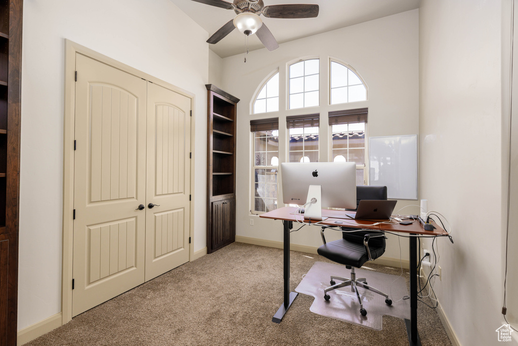 Home office with carpet flooring and ceiling fan
