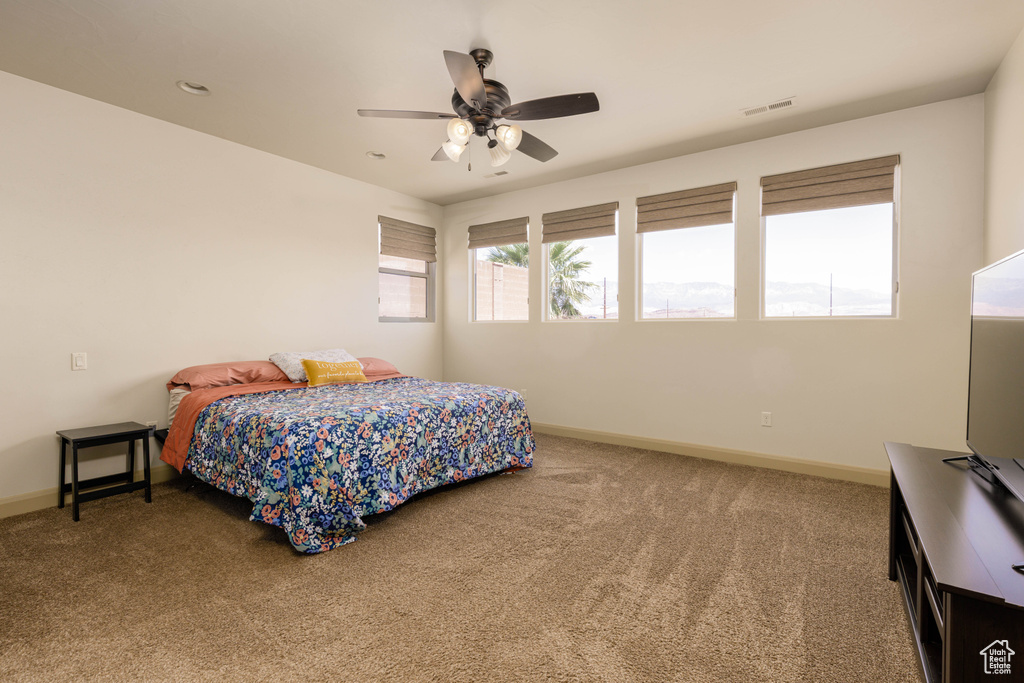 Carpeted bedroom featuring baseboards and ceiling fan