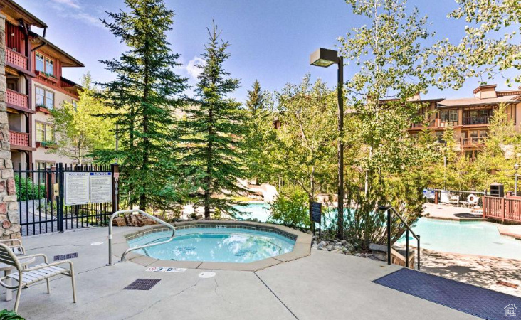 Community pool featuring a hot tub and a patio