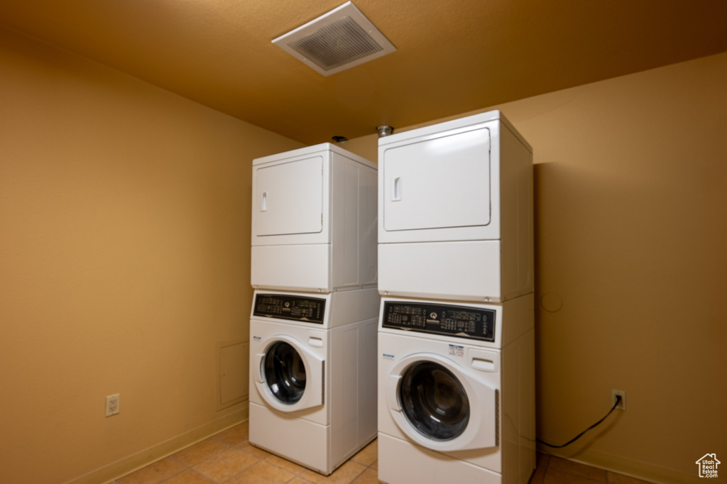Washroom featuring estacked washer and dryer and light tile patterned floors