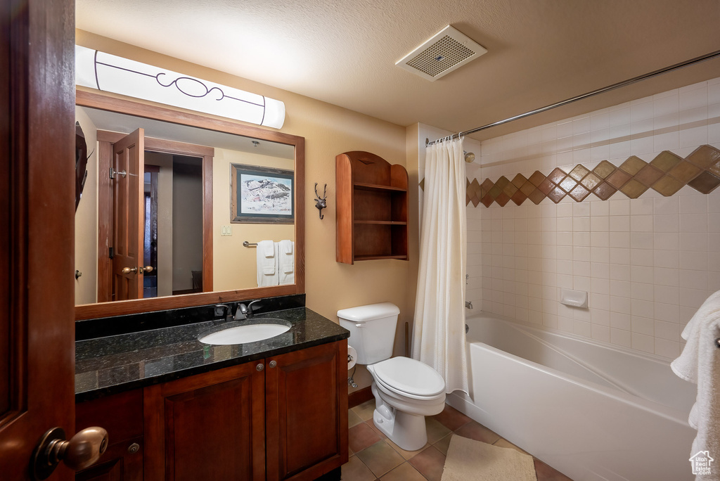 Full bathroom featuring shower / bath combo, vanity, and tile patterned floors