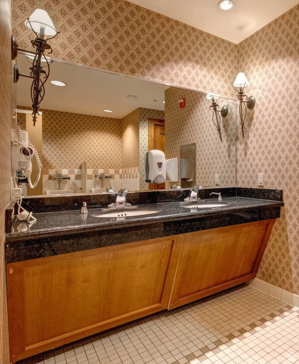 Bathroom with double vanity, tile patterned floors, wallpapered walls, and recessed lighting