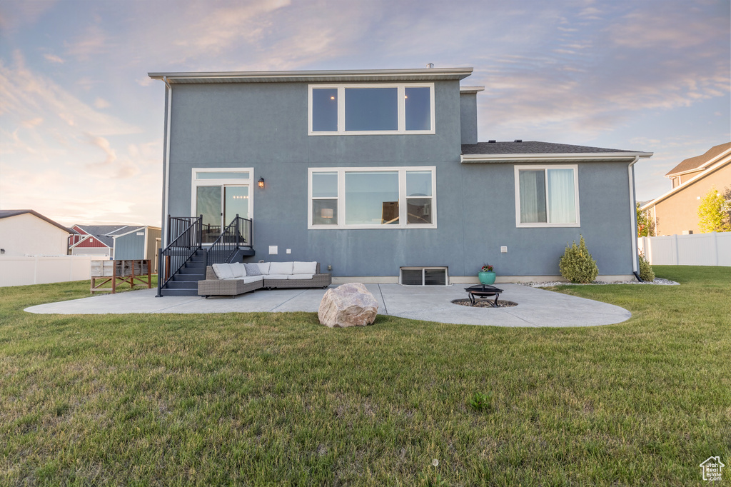 Rear view of property featuring a patio, an outdoor hangout area, and stucco siding