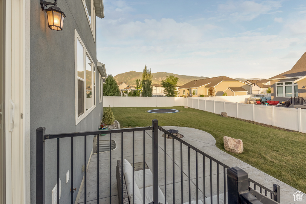 Fenced backyard featuring a patio area, a residential view, and a mountain view