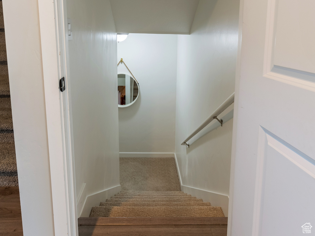 Staircase with baseboards and wood finished floors