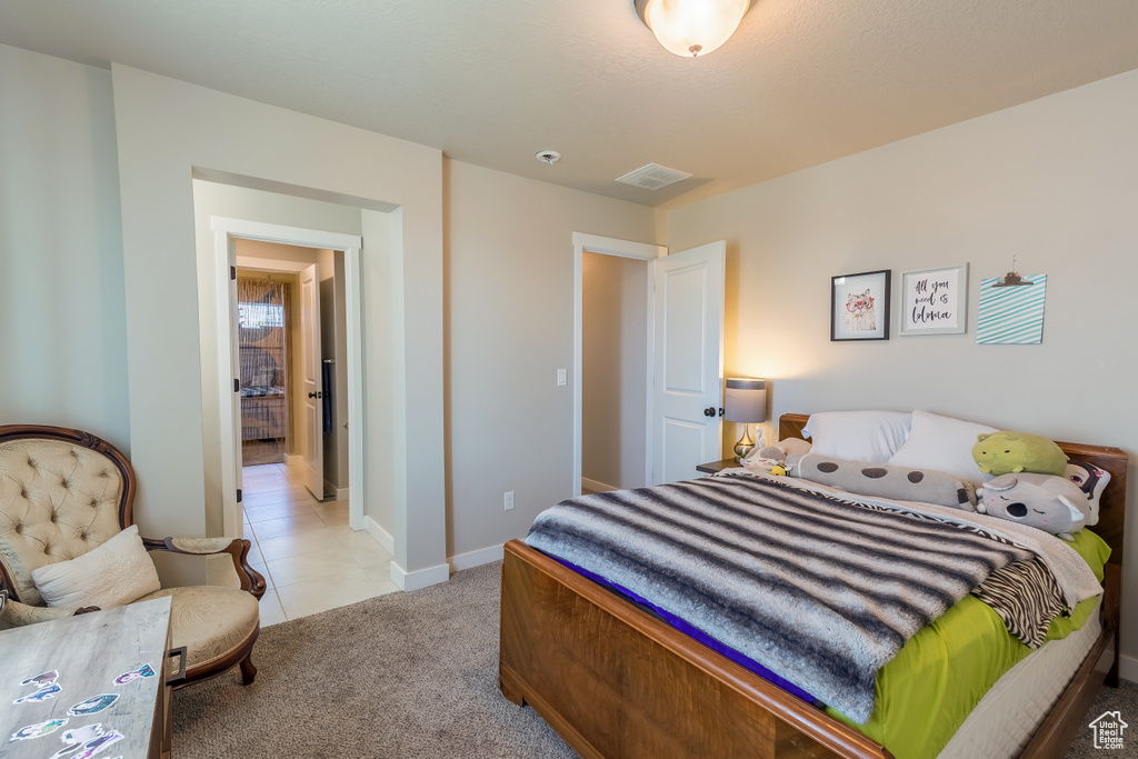 Bedroom featuring light colored carpet and light tile patterned flooring