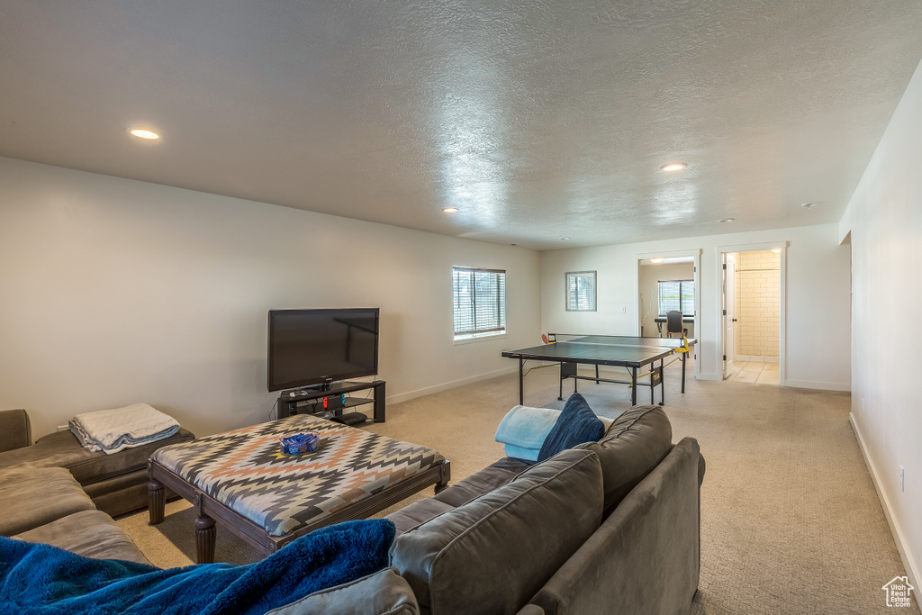 Living area with light colored carpet, recessed lighting, and a textured ceiling