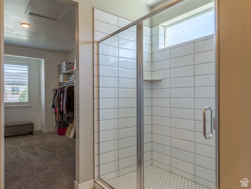 Bathroom featuring a textured ceiling, a stall shower, and tile patterned flooring