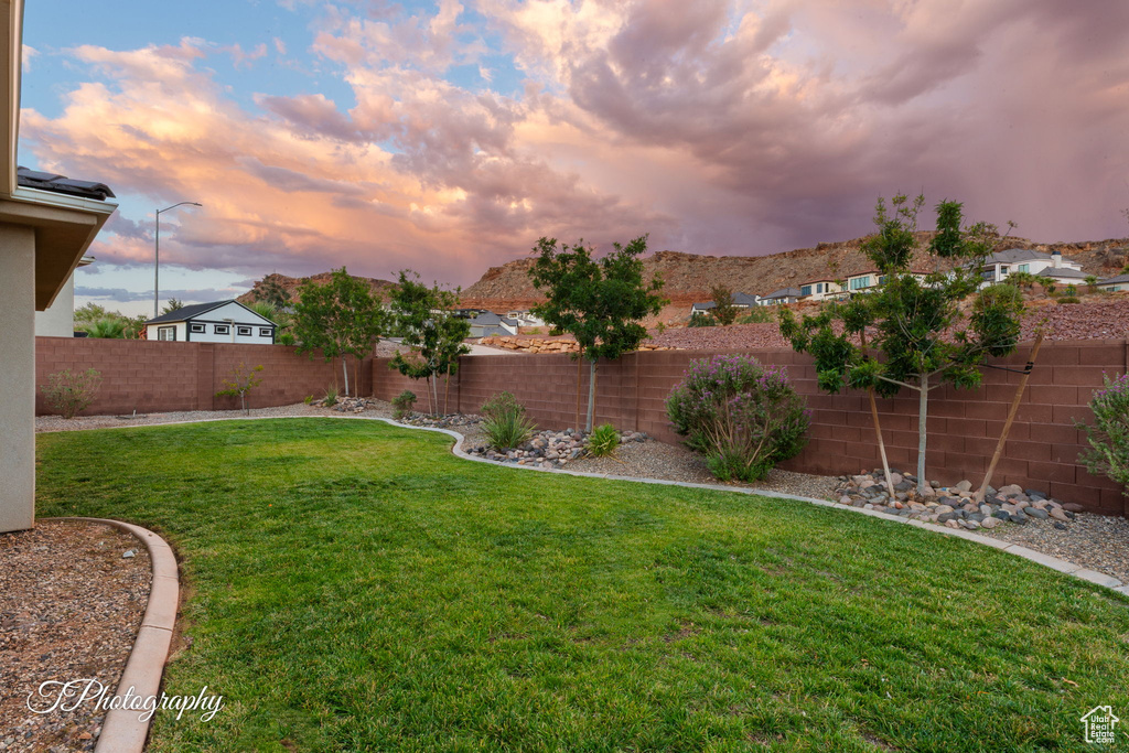 Yard at dusk featuring a fenced backyard
