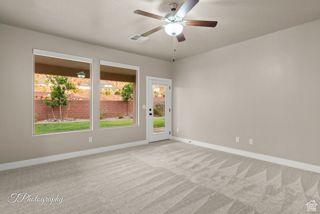 Spare room featuring light carpet and a ceiling fan